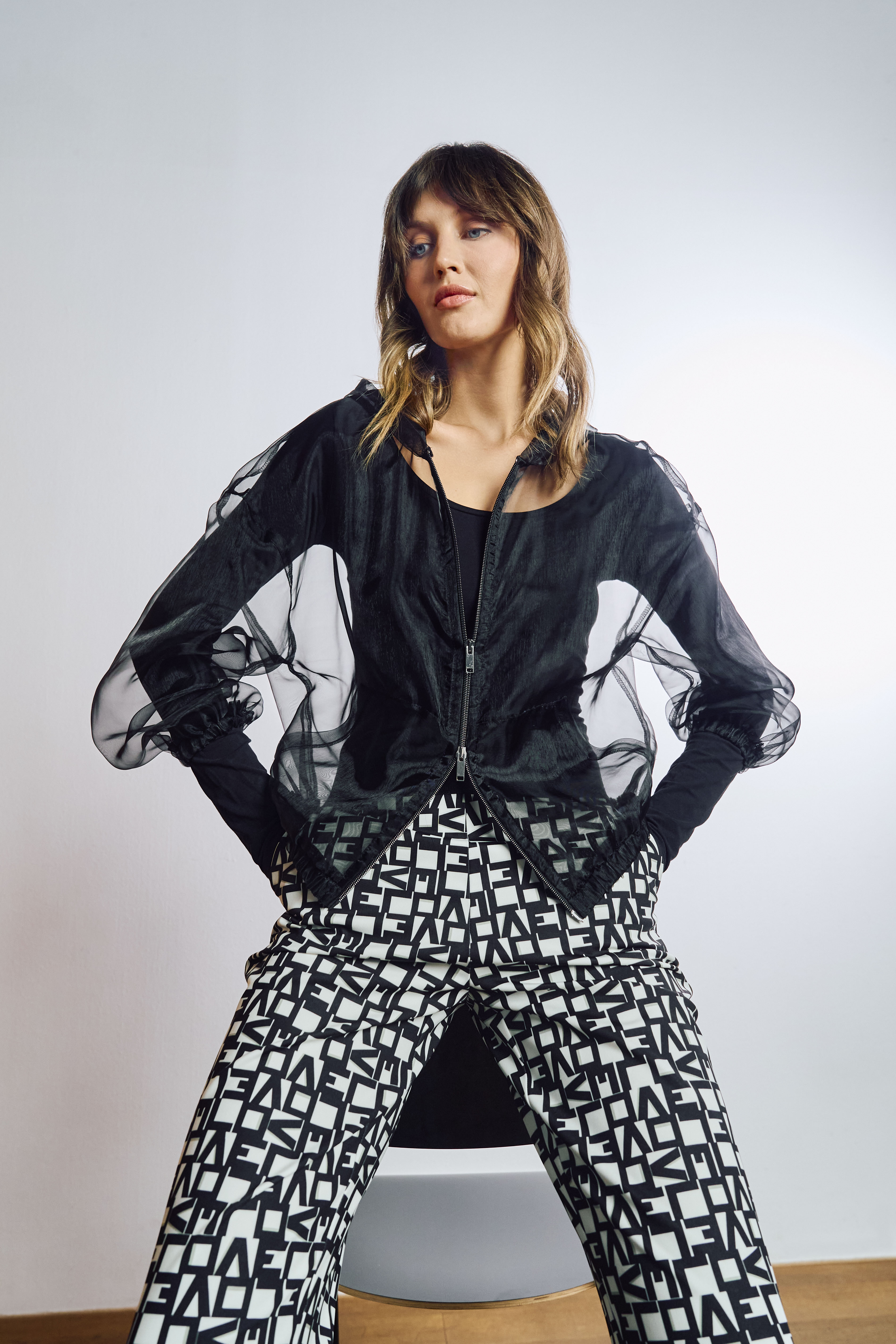 black jacket, sheer sleeves, zipper jacket, geometric pants, black and white pants